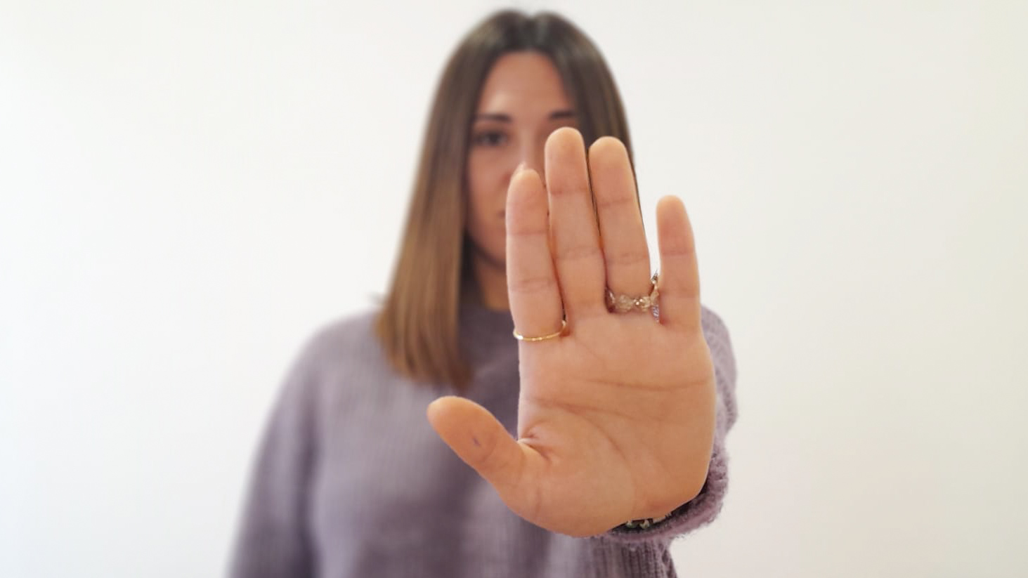 Una dona amb el braç estès mostra el palmell de la mà, en senyal de No.